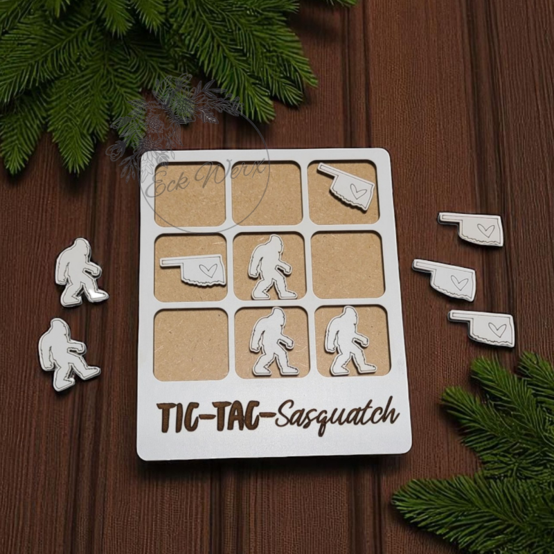 Tic-Tac Sasquatch game set on a wooden surface with Christmas tree branches.